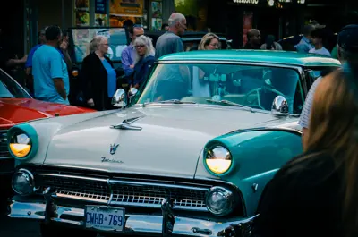 classic car surrounding by people
