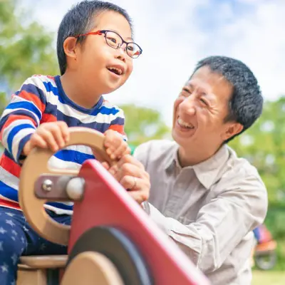 Father with low vision child on slide