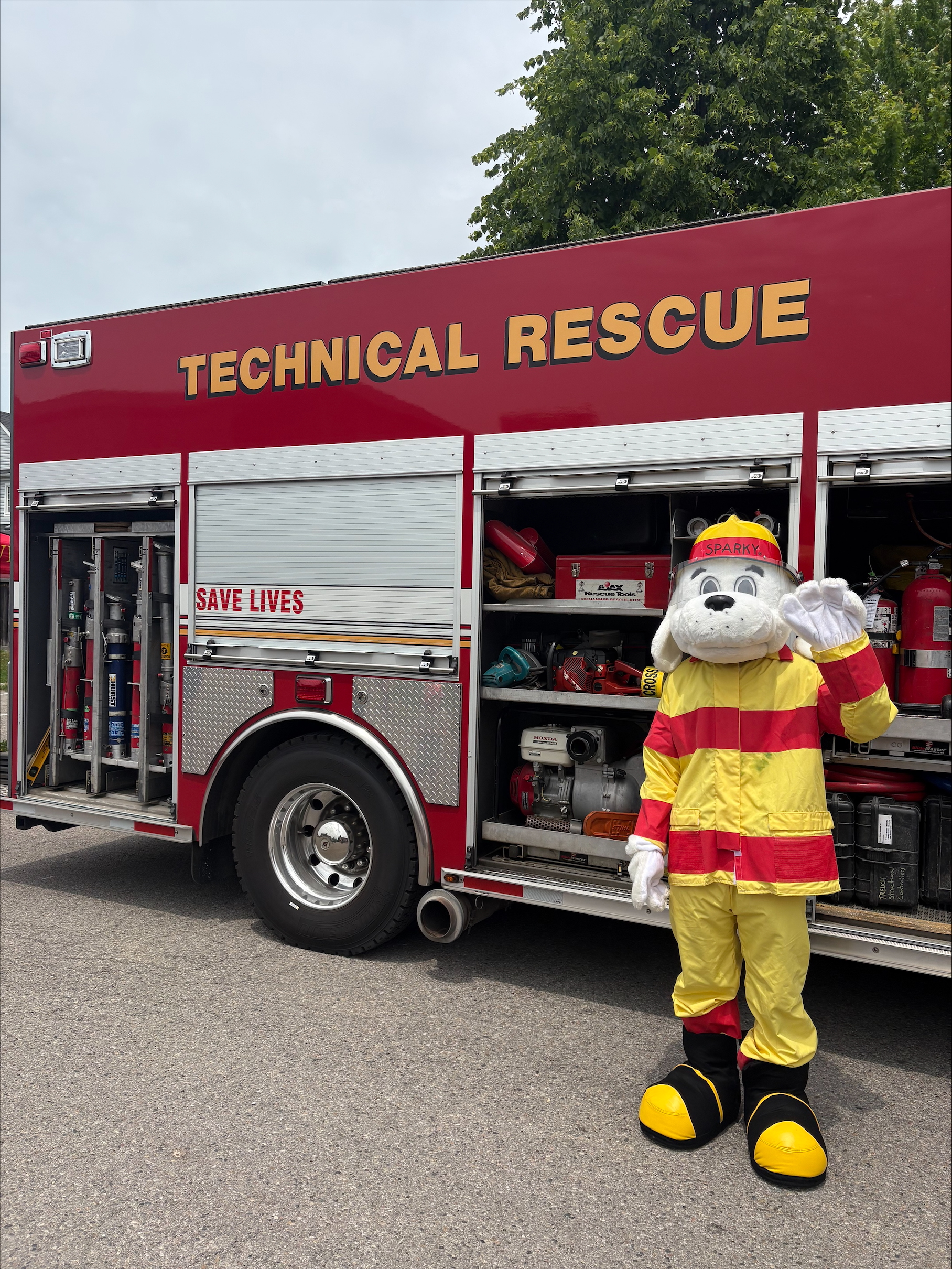 Sparky dog mascot  in front of fire truck