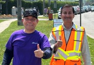 Two volunteer men outdoors, smiling and giving a thumbs up hand gesture