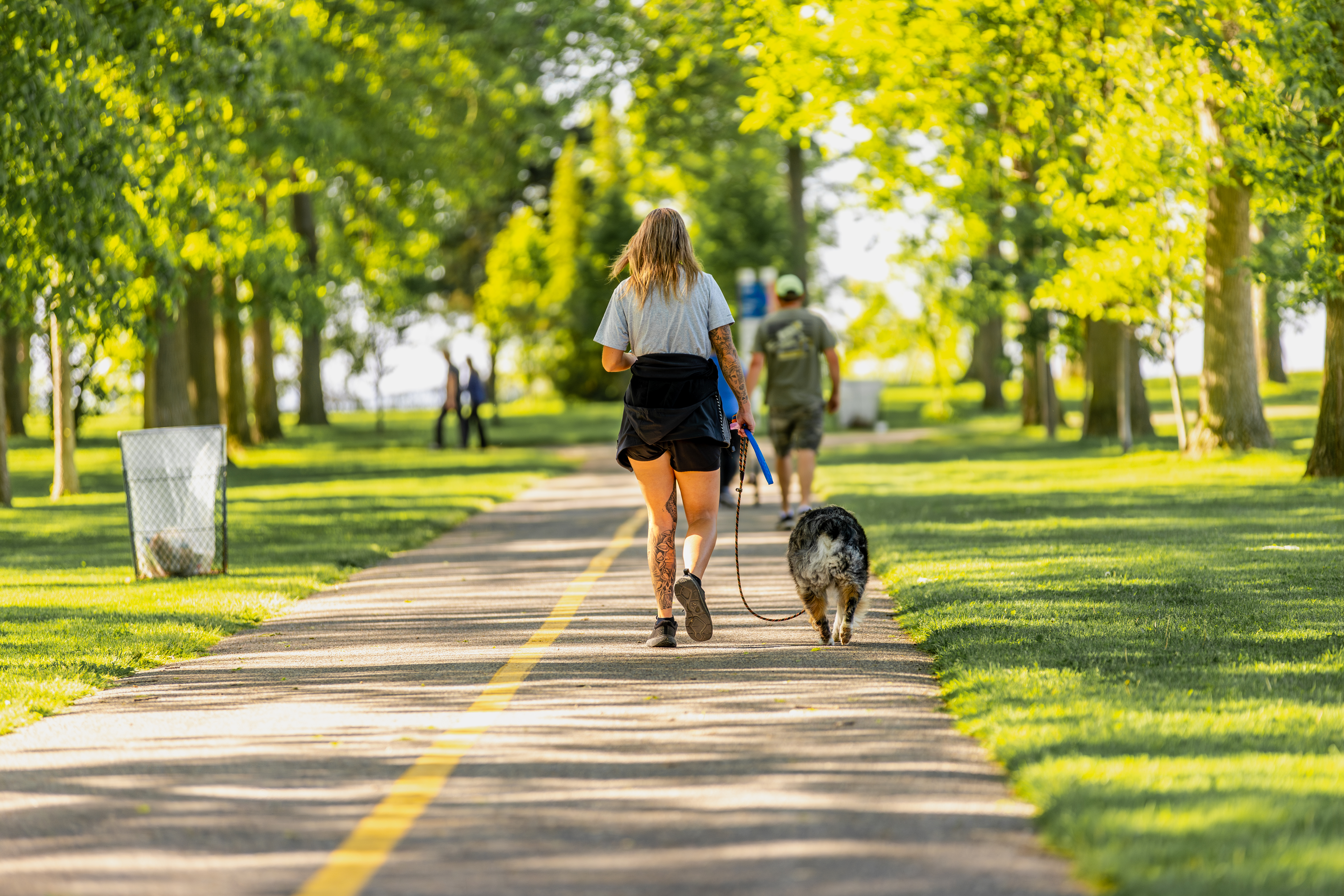 Woman walking a dog on Oshawa waterfront trail