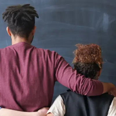 the backs of people with their arms wrapped around each other