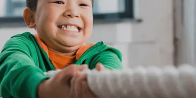 smiling child pulling on a thick rope