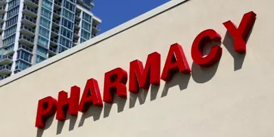 Red Pharmacy letters on the side of a white building