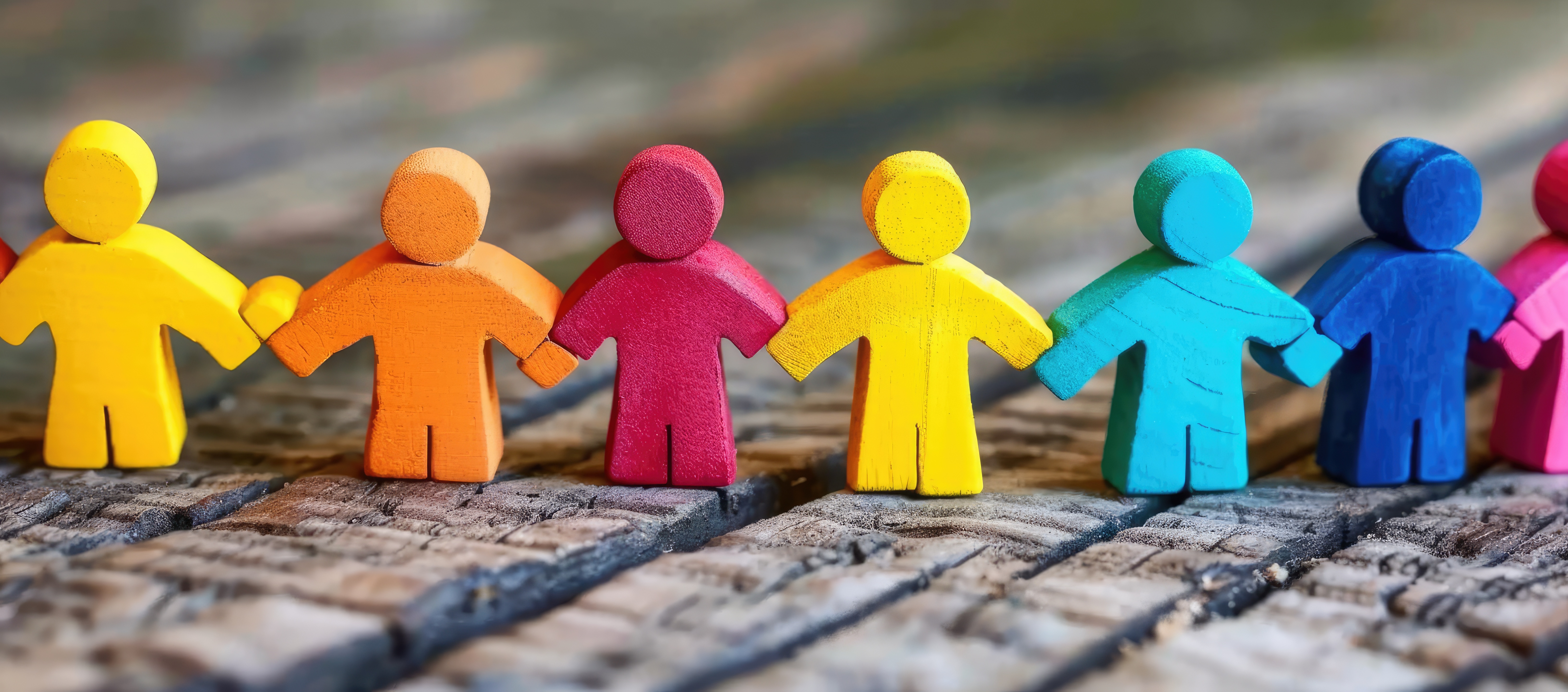 row of wooden people in a variety of colours