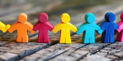 row of wooden people in a variety of colours