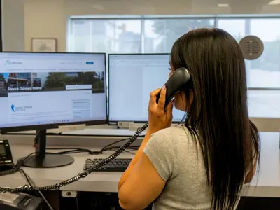 employee working on computer and phone