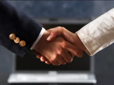 arms wearing suits shaking hands