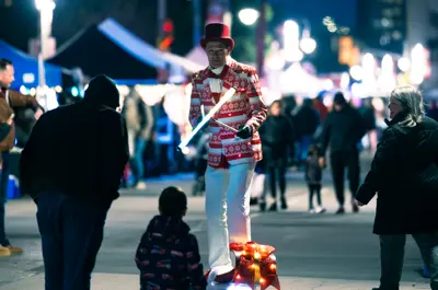 juggler riding a scooter through vendor market