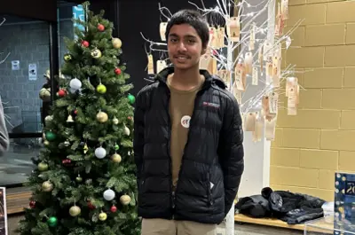 youth standing in front of Christmas tree