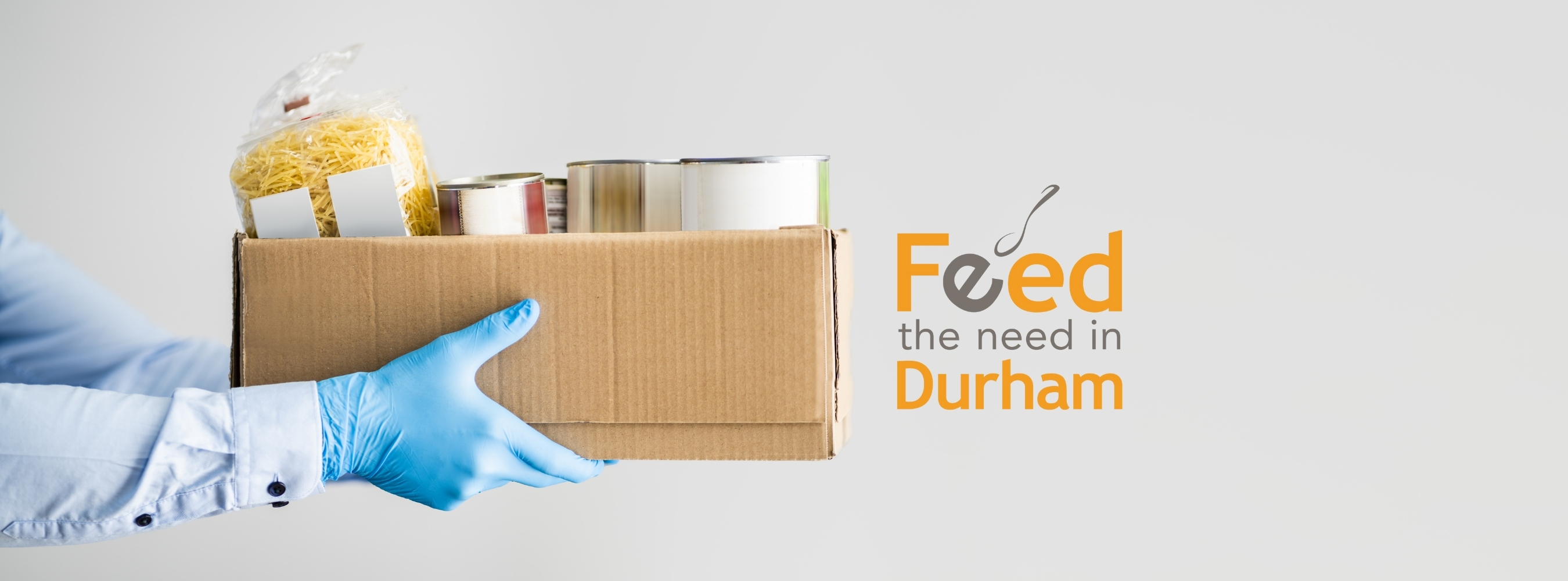 person holding a box of food witht the Feed the Need logo