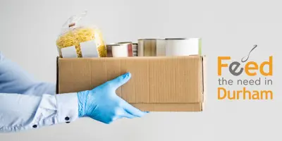 person holding a box of food witht the Feed the Need logo
