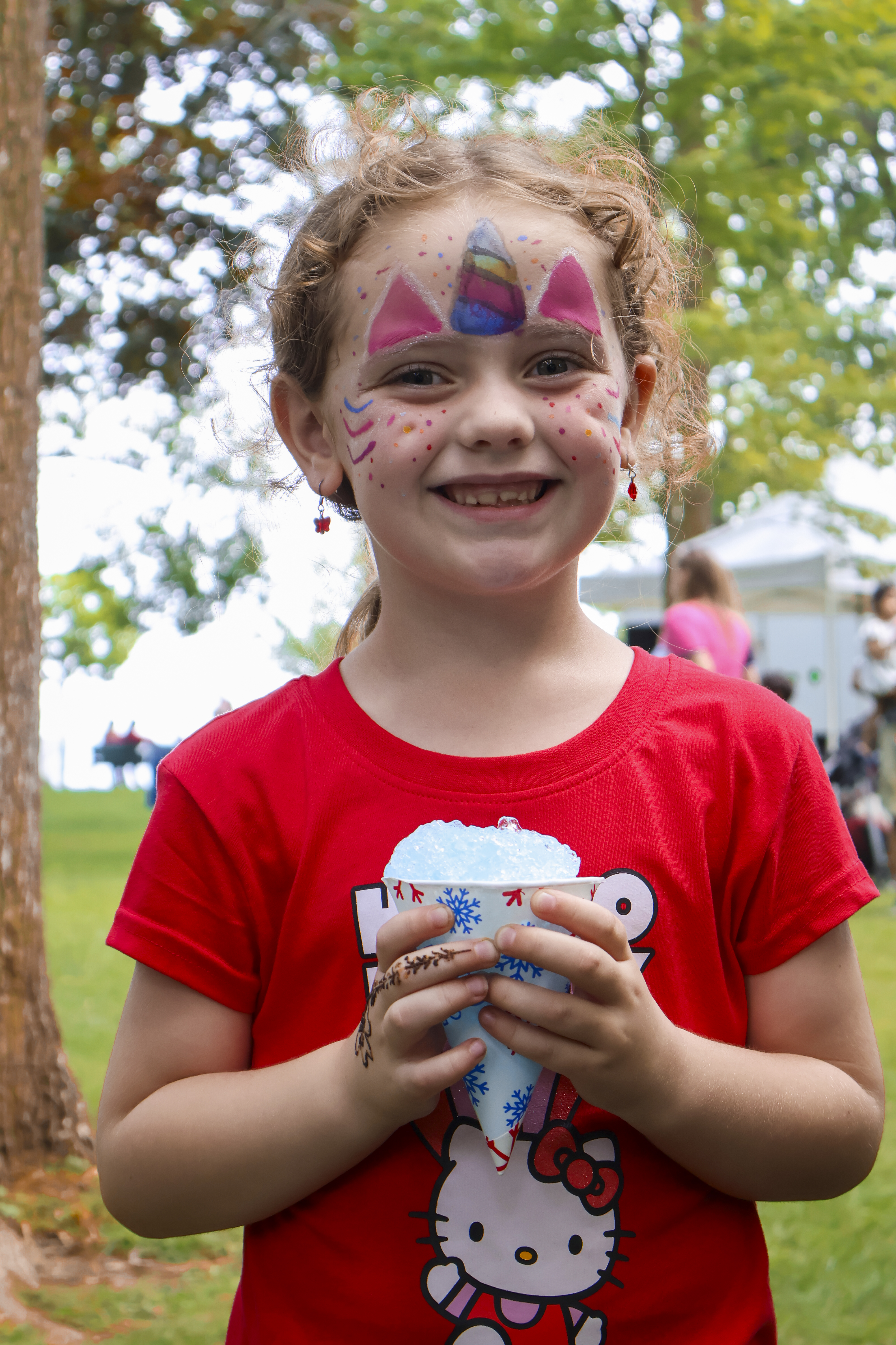 girl with face paint and snowcone