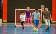 Kids playing soccer in gymnasium